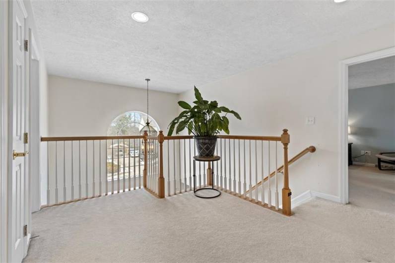 Open upstairs foyer, offering a spacious and airy feel that connects the home’s upper level with elegance and flow.