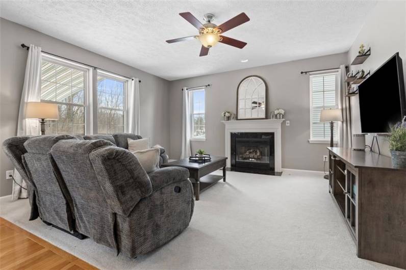 Bright and inviting family room with a cozy fireplace and a stunning wall of windows!