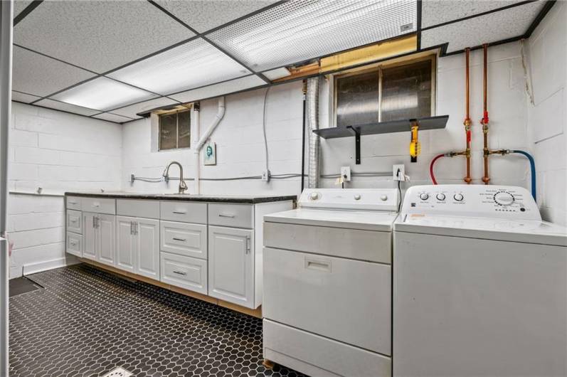 Separate laundry room with cabinetry and countertop