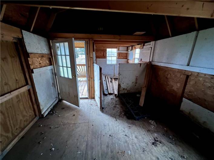 Inside the barn where there's loft space above on both sides and small animal pen!