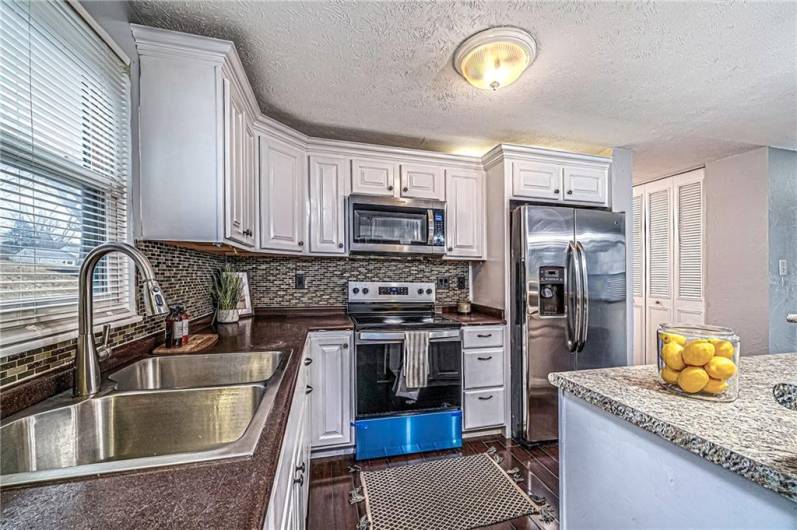 The kitchen is a true highlight featuring white cabinetry and stainless steel appliances.