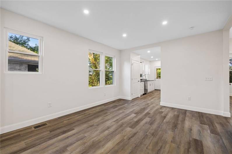 Sunny living room with lots of windows, modern open floor plan and recessed lighting.