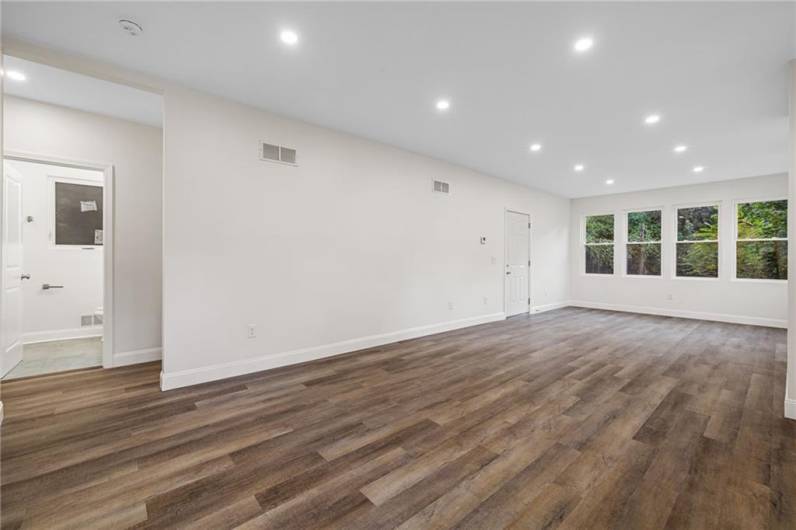 Sunny living room with lots of windows, modern open floor plan and recessed lighting.