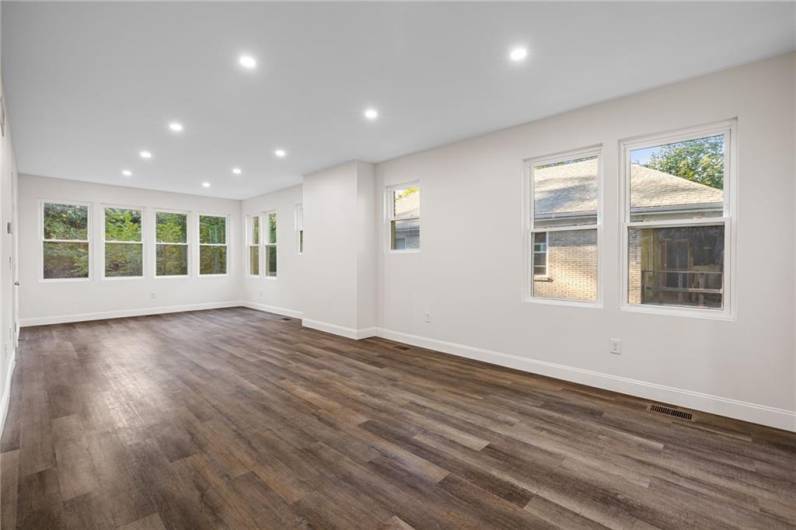 Sunny living room with lots of windows, modern open floor plan and recessed lighting.