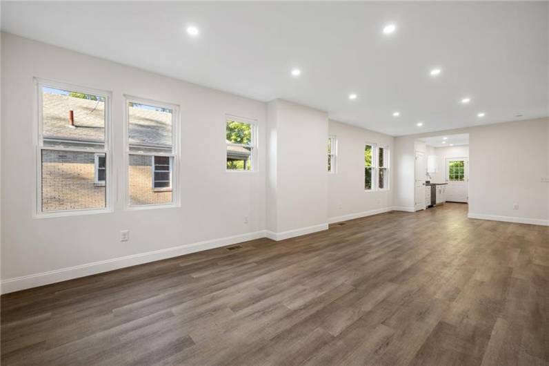 Sunny living room with lots of windows, modern open floor plan and recessed lighting.