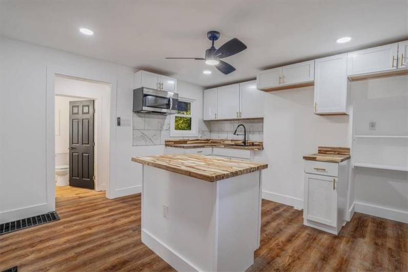 Brand new kitchen with butcher block countertops, new cabinets, new lighting and floors!