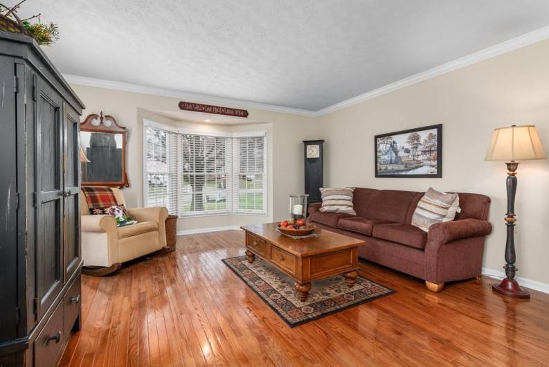 Living room or flex space has hard wood floors and bump out side window