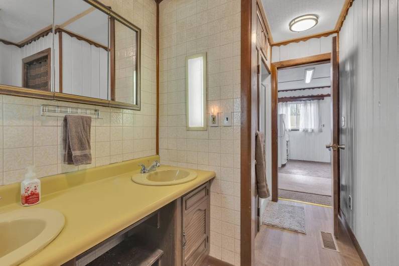 Owner's bathroom has double sinks, brand new floor, shower light, toilet- 01/2025.  Shower to left was updated by current owner. Toilet to right.