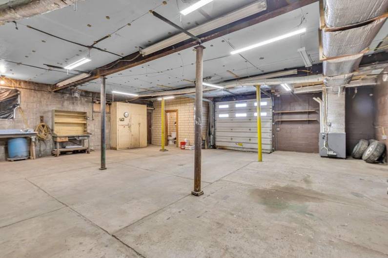 View from rear of this garage of entry/full bath and entrance to next garage.