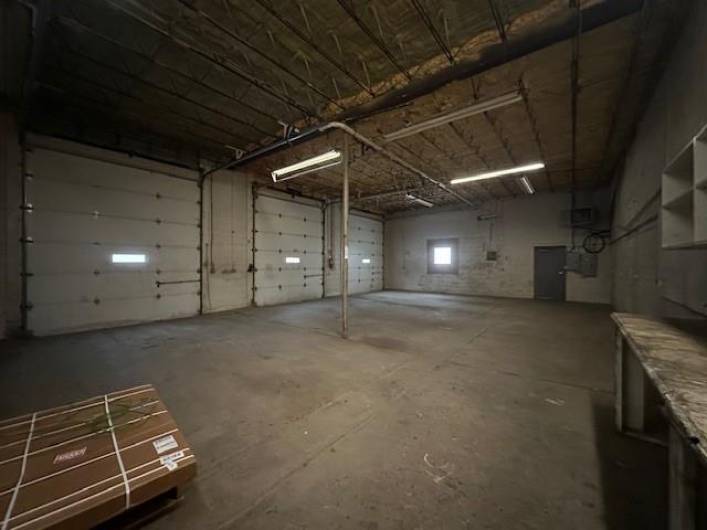 Other 3 garage doors open into a large, open, heated garage space.