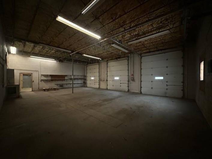 Other 3 garage doors open into a large, open, heated garage space.