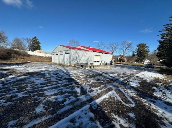 4 Garages in rear of building. 1st Door is single insulated garage with heat and mandoor to outside. Other 3 garage doors open into one large heated space. Garage door on side of building goes into huge warehouse space.