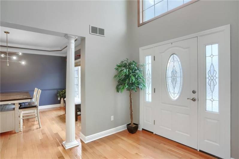 An elegant dining room is adjacent to the grand two story foyer, and features columns.