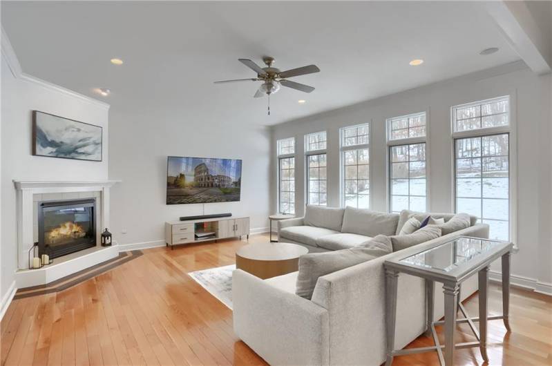 Settle into the family room and soak in the warmth of the fireplace.  Hardwood flooring, crown molding and a wall of windows are highlights.