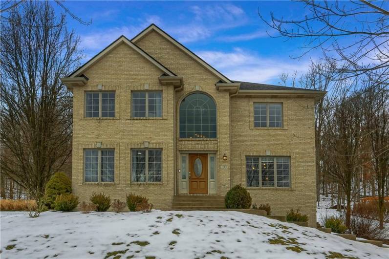 Well manicured landscaping complements the brick home.