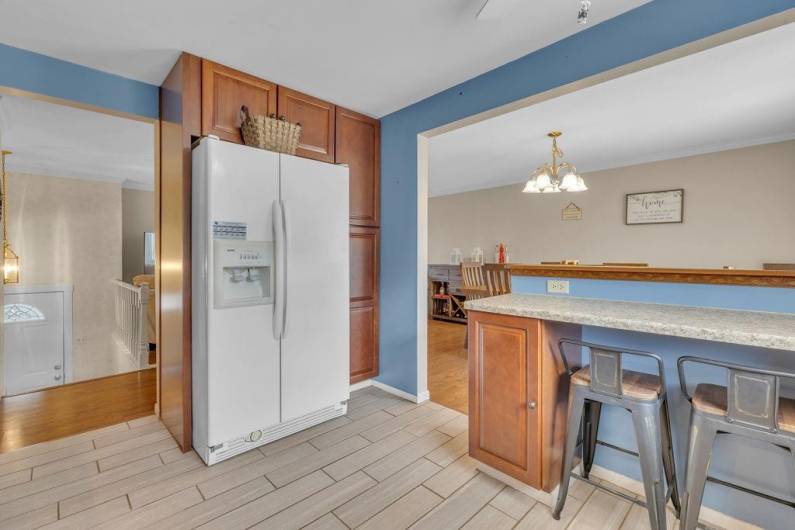 Kitchen has beautiful ceramic tile and two counter seats.