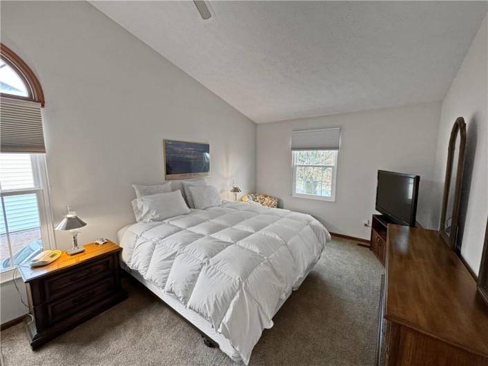 The master bedroom features a dramatic vaulted ceiling and brand new carpeting.