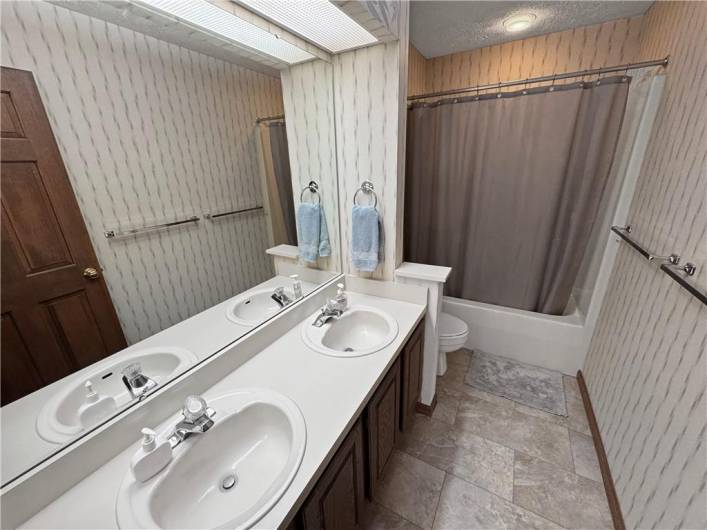 Main bath on the second floor has a dual bowl vanity sink and brand new flooring.