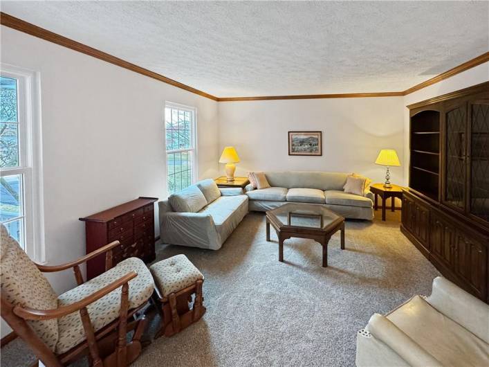 Crown molding accent the living room with brand new carpeting.