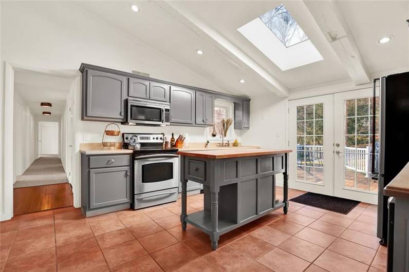 Another view of kitchen features skylight and French doors to access the deck