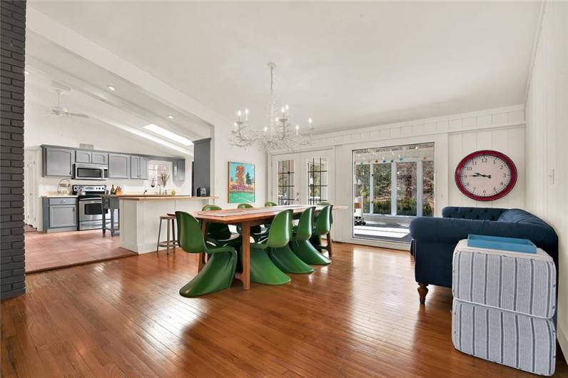 Open floor plan to kitchen and French doors leading to the sunroom.