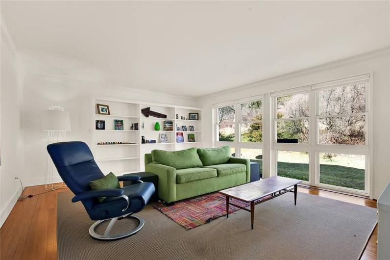 Family room with built-in bookcase and large windows. This could also be used as a bedroom or an office.