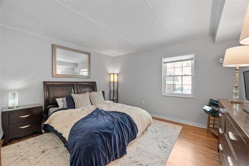 Primary bedroom with wall of closet with built-in closet organizer.  LVP flooring