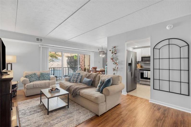 Living room with LVP flooring  Full glass sliding door to covered patio.