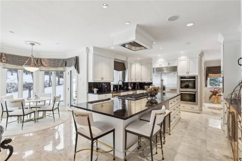 Inviting open kitchen with octagonal breakfast full length windows with walk out to the side patio and rear yard.