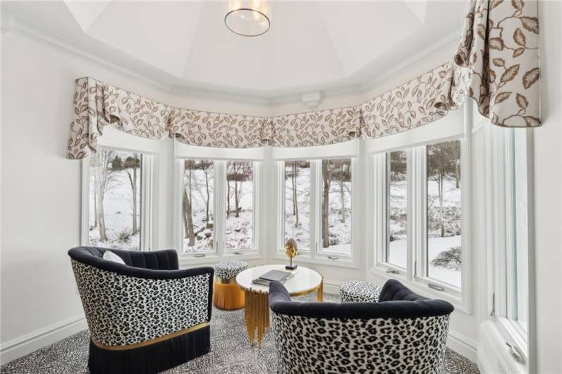 Sitting area flanked by widows with electronic blinds with breathtaking views.