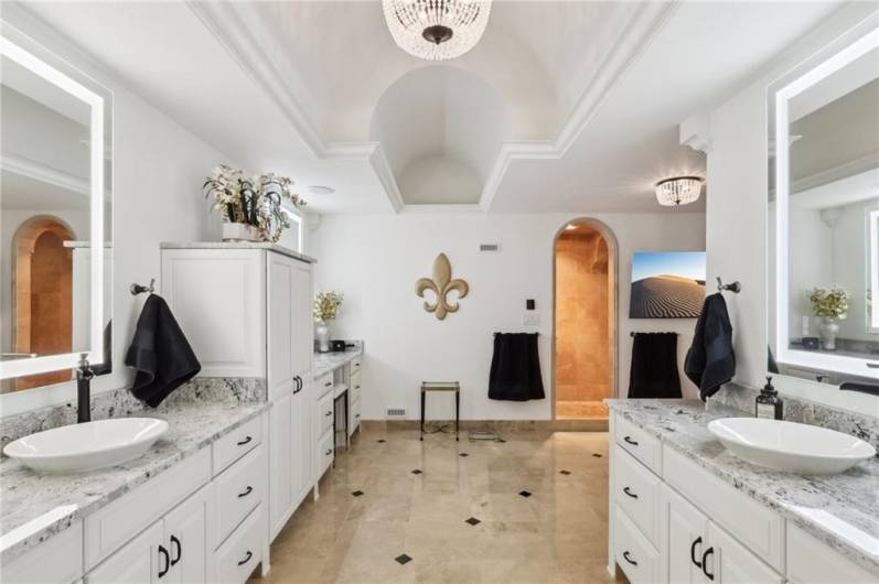 Spectacular Spa-Like en-suite bath with triple vanities, granite counter-tops, custom lighted mirrors and Travrertine floors.
