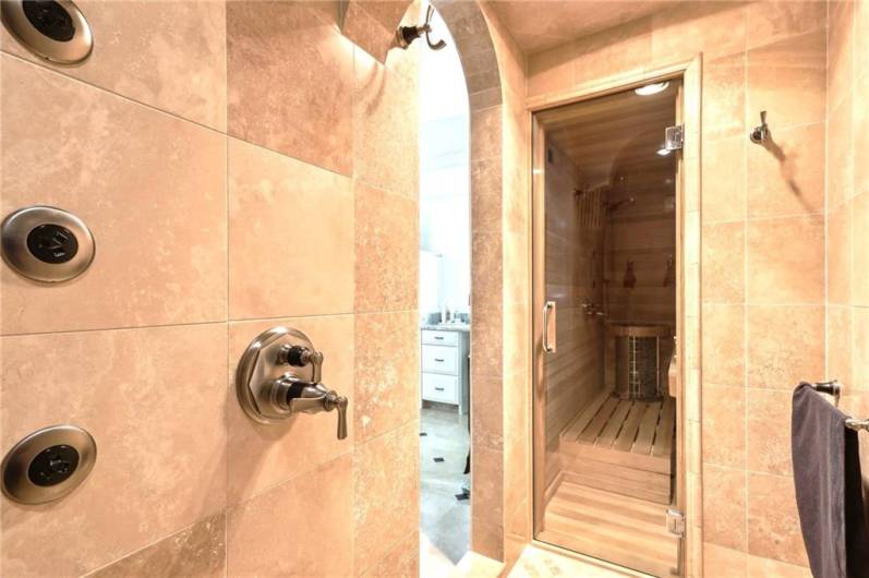 Spacious tile shower with body jets leading into the Sauna