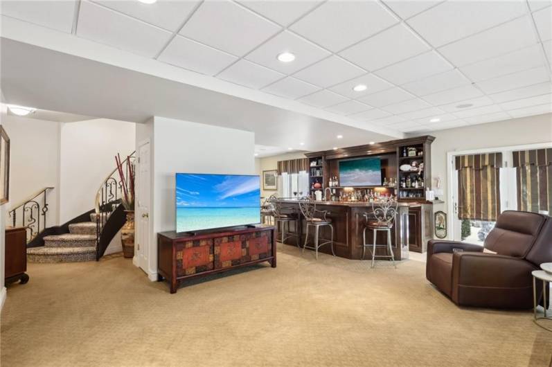 Media room opens to the bar area with glass doors leading to the side patio and private yard