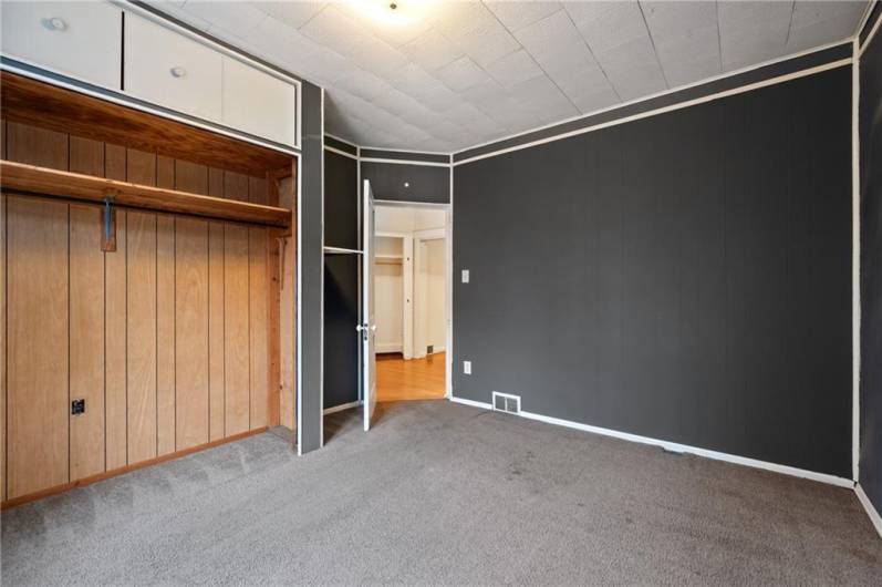 The primary bedroom features a large closet with storage above,