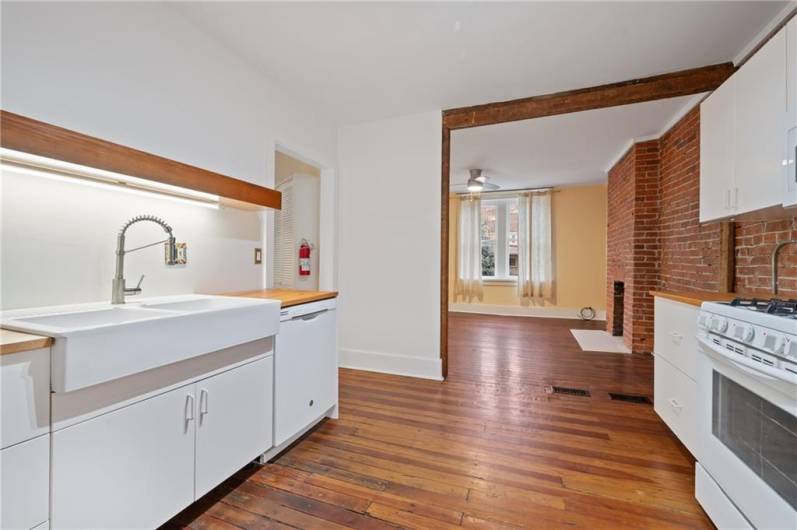 The wall was opened further in this unit, into the living room. One of the great details here is the exposed brick wall. Adds lots of character.