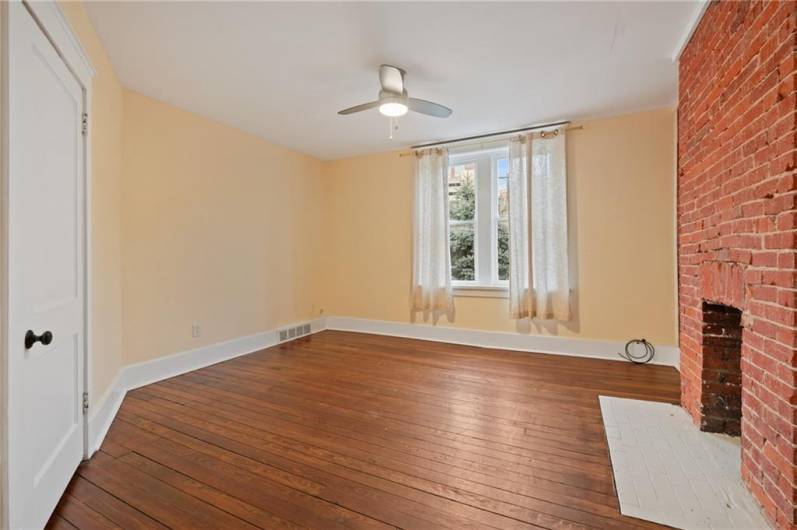 Hard wood floors, exposed brick, ceiling fan and a utility closet, are all nice bonus features to the living room.