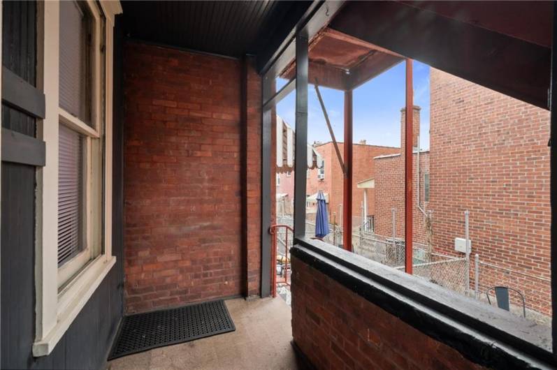 This is one of the covered back balconies. From here is an additional safety exit and staircase down to the fenced in yard below.