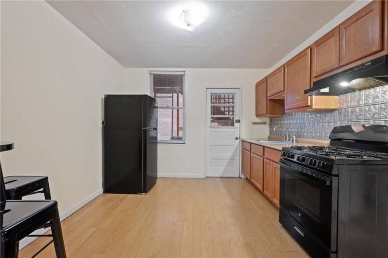 Brand new gas stove and refrigerator! Newer flooring. Door to the back covered balcony. Eat-in size kitchen.