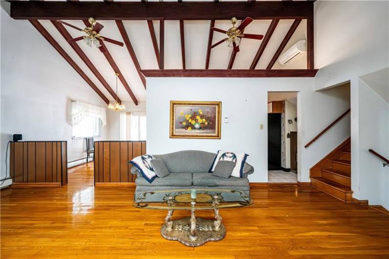 LIVING ROOM FACING THE BACK OF THE HOUSE SHOWING THE DINING ROOM ON THE LEFT AND THE STAIRCASE TO THE UPPER FLOORS WHERE THE BEDROOMS ARE LOCATED