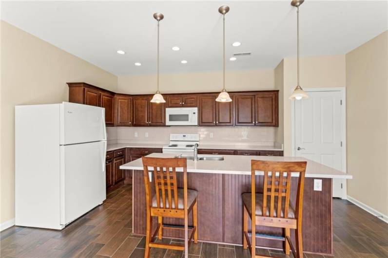 Plenty of Cherry Wood Cabinetry in 21x17 Eat-in Kitchen w/ Kitchen Island Breakfast Bar and Stools included! Quality Granite Counter Tops & Attractive Ceramic Tile Flooring Deep 8x6 L Shaped Walk-in Pantry w/ Shelves.Refrigerator, Electric Stove, Microwave, Dishwasher & Garbage Disposal Included in Sale.