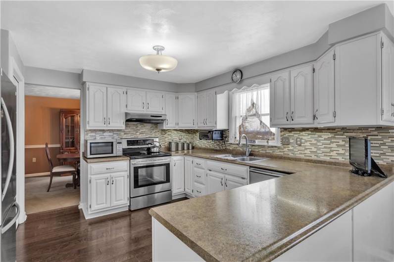 Sleek kitchen countertops & view into the inviting dining room!