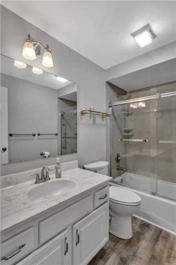 Full Bathroom including many updates such as new paint, shower, shelving, & luxury vinyl flooring