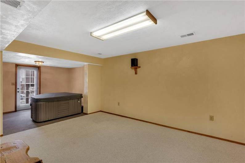 Finished walk-out basement shows a designated hot tub room complete with ventilation and relaxing views!