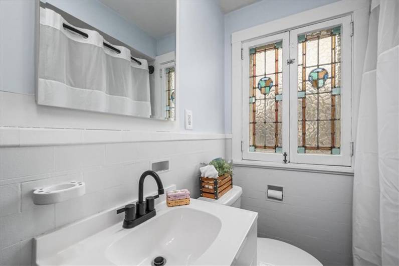 Upstairs updated bathroom with gorgeous original stained glass windows.