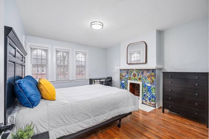 Ample primary bedroom with stunning custom decorative fireplace