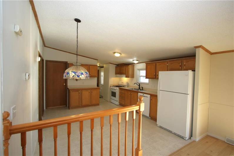 Nice Sized Eat-in Kitchen w/ Lots of Oak Cabinets. Additional Shelved Storage / Pantry in adjacent Laundry Rm Oak Railing subtly separates from 16x26 Great Room!