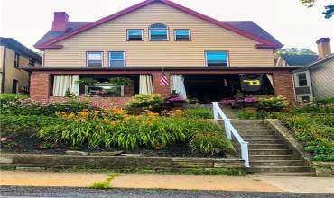 Such an inviting front porch, perfect for relaxing with a morning coffee or greeting neighbors. Lined with charming flower beds, the front yard bursts with colorful blooms as flower bulbs awaken this spring, adding a fresh, cheerful touch. The classic Victorian architecture, with its detailed woodwork and welcoming entryway, enhances the home's timeless curb appeal.