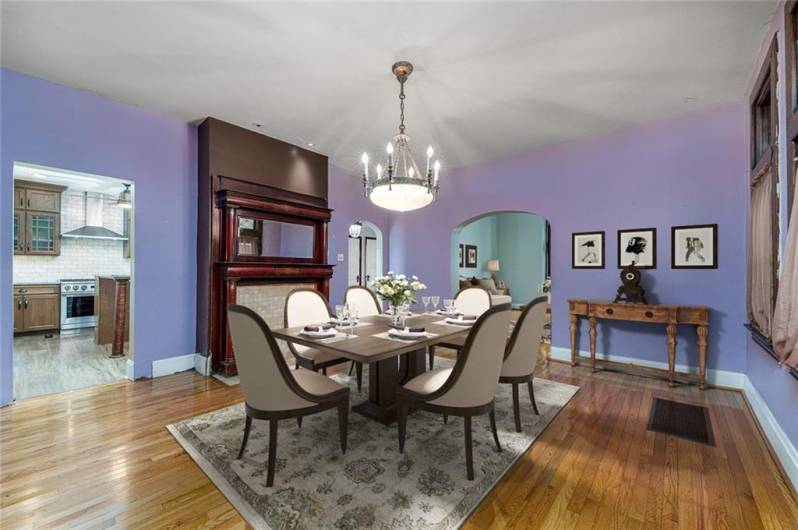 This elegant dining room is the perfect blend of warmth and sophistication, featuring a custom decorative fireplace that adds charm and character. A beautifully crafted wood accent wall enhances the space, creating a rich, inviting ambiance. Seamlessly connected to the kitchen, this room is ideal for hosting gatherings or enjoying everyday meals in a setting that feels both cozy and refined.