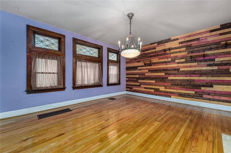 This elegant dining room is the perfect blend of warmth and sophistication, featuring a custom decorative fireplace that adds charm and character. A beautifully crafted wood accent wall enhances the space, creating a rich, inviting ambiance. Seamlessly connected to the kitchen, this room is ideal for hosting gatherings or enjoying everyday meals in a setting that feels both cozy and refined.