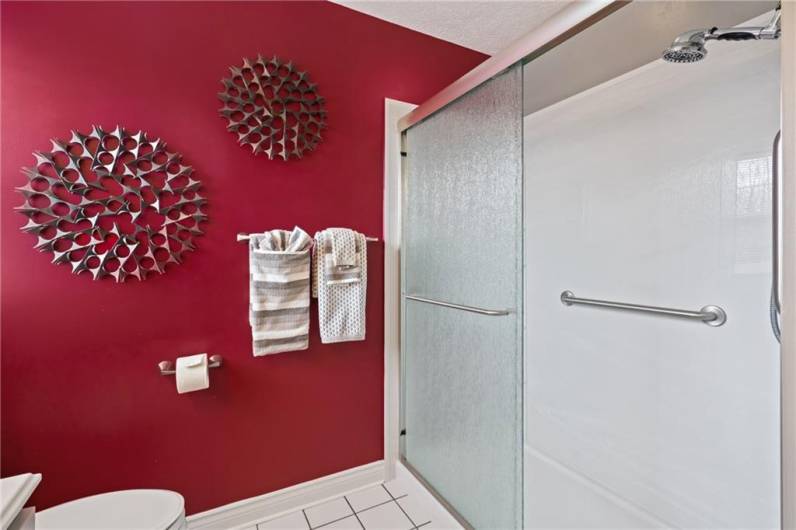 The newly remodeled primary bath features an oversized walk-in shower with upscale glass doors.